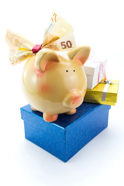 Piggy bank with a banknote bow and gift boxes — Stock Photo, Image