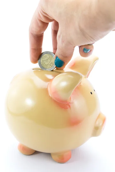 Hand storten munt in piggy bank geïsoleerd op wit — Stockfoto