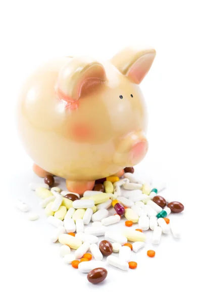 Piggy bank with pile of pills isolated on white — Stock Photo, Image