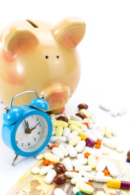 Skarbonka z kupie tabletki, banknotów i zegar na białym tle