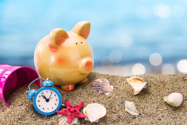 Piggy bank di atas pasir dengan latar belakang laut musim panas — Stok Foto