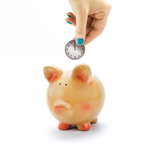 Ręka, deponując monety z wybierania zegar skarbonkarukou úložkách mince s hodinami vytáčení v prasátko — Stockfoto