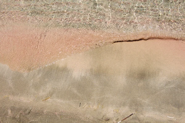 Wet pink sand washed by sea tide background — Stock Photo, Image