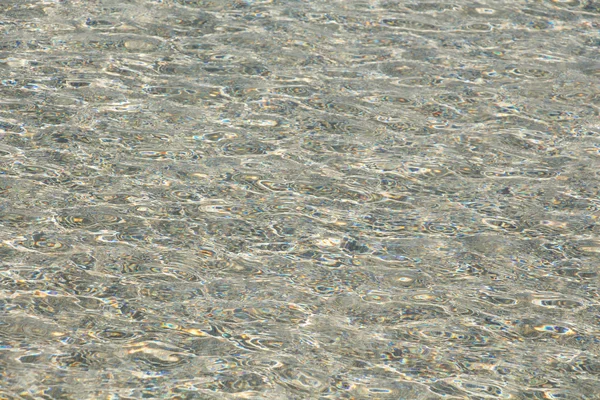 Transparante duidelijk zachte golfde water oppervlakte achtergrond — Stockfoto