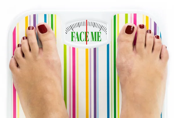 Füße auf Badezimmerwaage mit den Worten "face me" auf dem Zifferblatt — Stockfoto