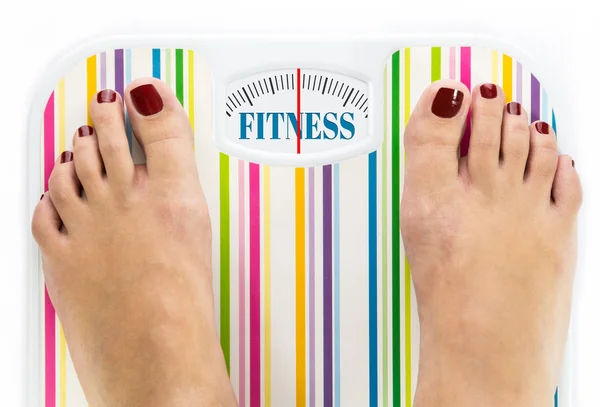 Voeten op de badkamer schaal met woord "fitness" op dial — Stockfoto