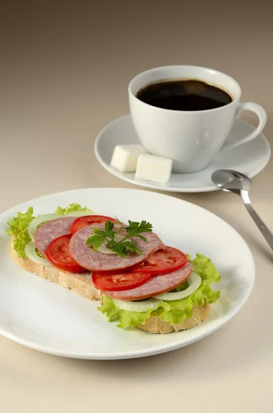Sanduíche com um cervelat e café . — Fotografia de Stock