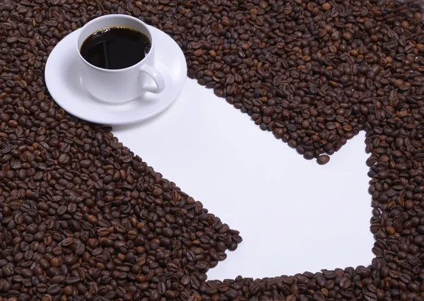 Nyíl és szemes kávé egy csésze kávé. — Stock Fotó