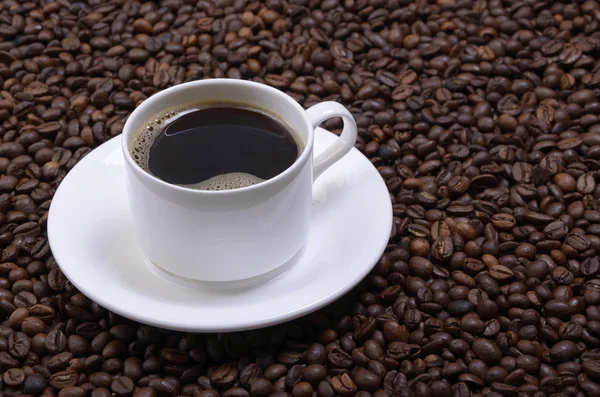 Csésze kávé szemben a szemes kávé. — Stock Fotó