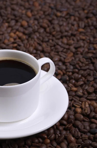 Taza de café contra granos de café . Imagen De Stock