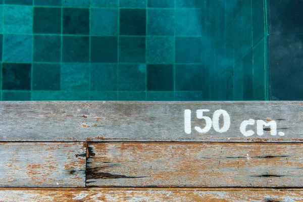 Schwimmbad Wassertiefenschild auf Holzplattform — Stockfoto