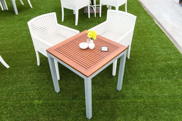 Tropické dřevěný jídelní stůl na zelené trávě — Stock fotografie
