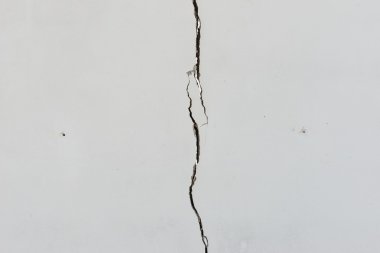 düz beyaz boyalı beton duvar üzerinde çatlaklar