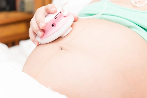 Giovane donna incinta tailandese ascoltare il bambino — Foto Stock