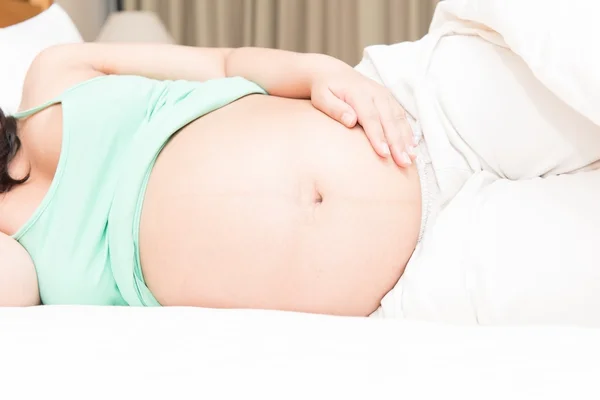 ベッドで眠っている若いタイの妊娠中の女性 — ストック写真