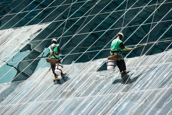 Glazenwassers reinigen een hoge stijging kantoorgebouw — Stockfoto