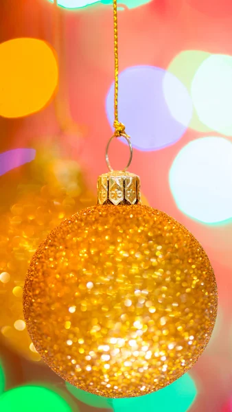 Golden christmas ball on bokeh background — Stock Photo, Image