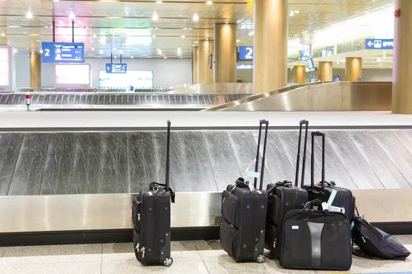 Maletas y banda de equipaje en el aeropuerto — Foto de Stock