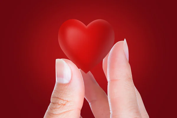 Coração vermelho na mão da mulher — Fotografia de Stock