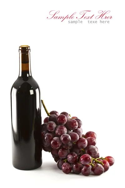 Una botella de vino tinto con uvas — Foto de Stock