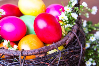 çiçekli kahverengi sepetteki renkli Paskalya yumurtaları