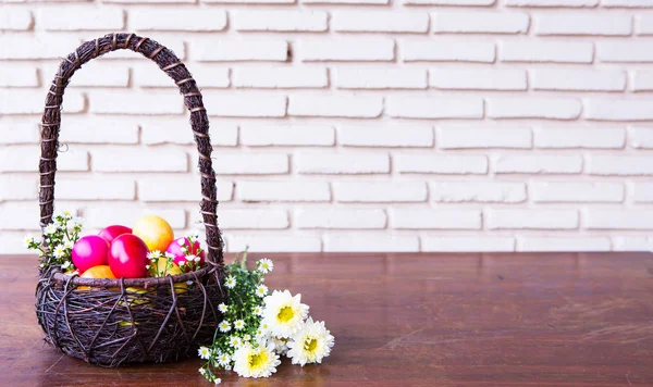 花と茶色のバスケットでカラフルなイースターエッグ — ストック写真
