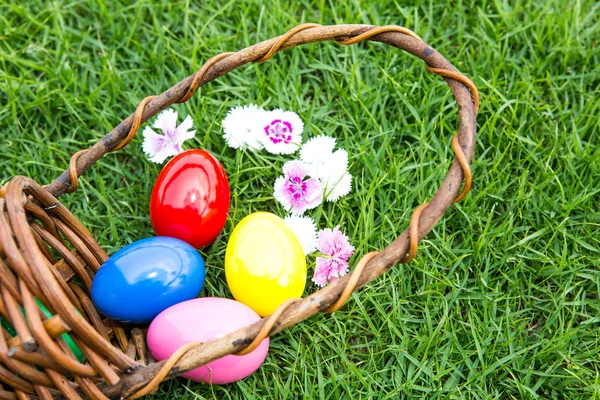 Basket of easter eggs on green grass — Stock Photo, Image