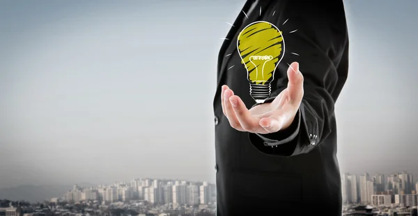 Business man holding light bulb in his hand — Stock Photo, Image