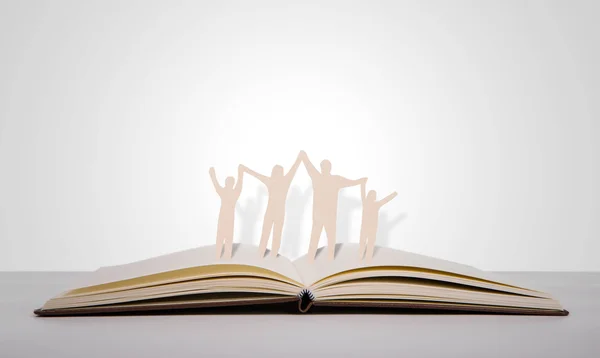 Paper cut family symbol on old book — Stock Photo, Image