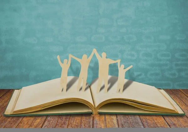 Paper cut family symbol on old book — Stock Photo, Image