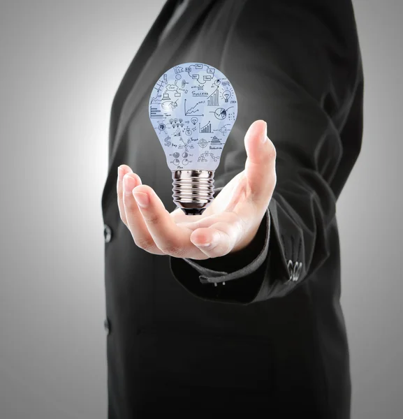 Business man holding light bulb with business concept inside — Stock Photo, Image