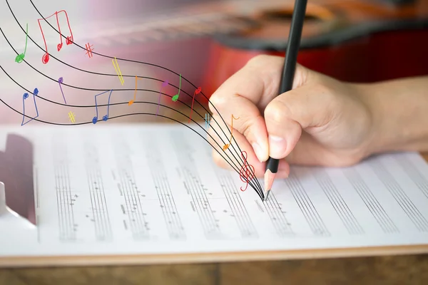 Hand with pencil and music sheet — Stock Photo, Image
