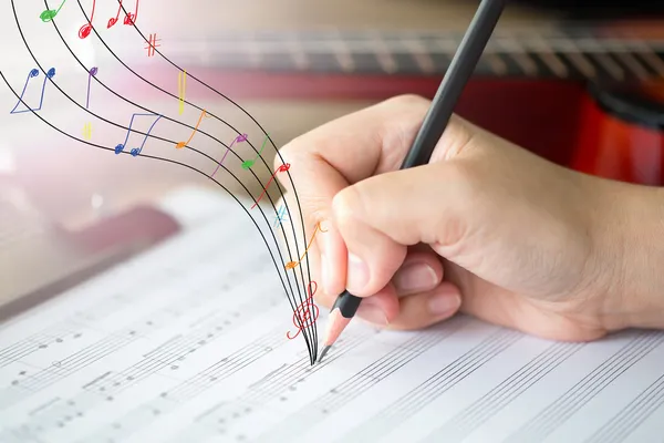 Mano con lápiz y hoja de música — Foto de Stock