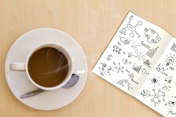 Taza de café caliente y libro con gráfico en mesa de madera — Foto de Stock