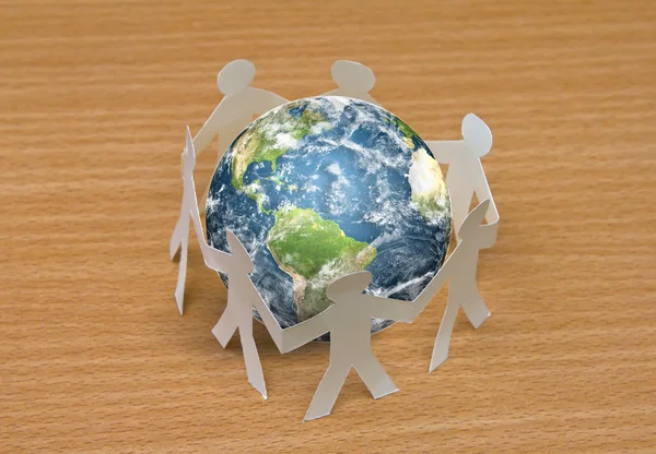 Paper cut of standing in a circle around globe on wooden — Stock Photo, Image