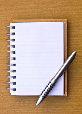 Not defteri ve kalem. ahşap masa katta.