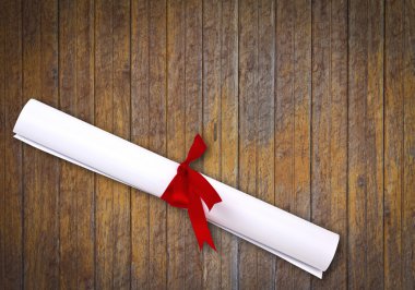 beyaz zemin üzerine kırmızı kurdele ile sarılmış diploma.