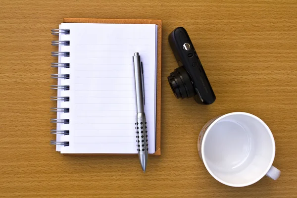 Livre de notes et stylo et tasse à café et appareil photo. Sur le sol de la — Photo