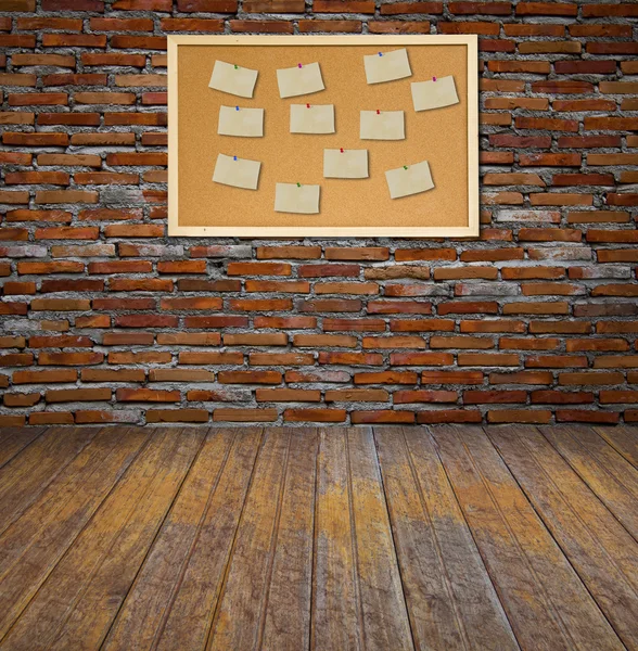Papan buletin cork dengan catatan kertas tua di dinding bata . — Stok Foto