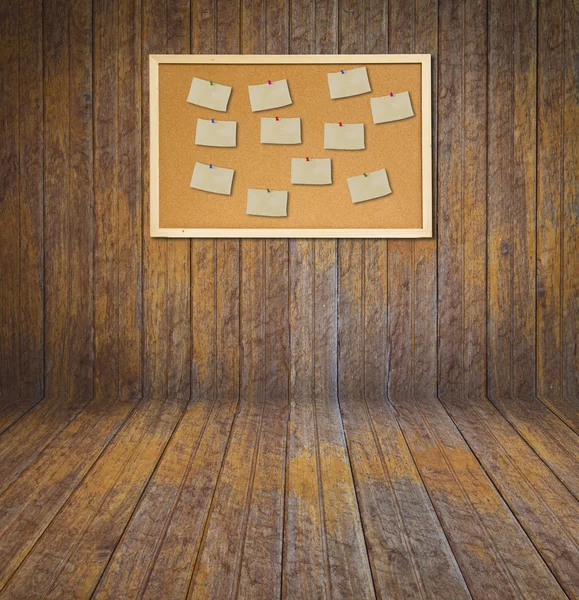 Cork bulletin board with old paper note on wood wall — Stock Photo, Image