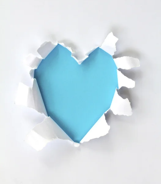 明るい青色の背景に隠れてに対して心臓形孔を有する紙のシート — ストック写真