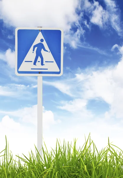 Verkehrsschild auf grünem Gras und blauem Himmel. — Stockfoto