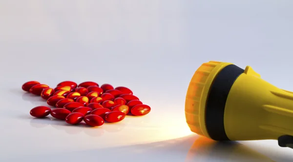 Yellow plastic pocket flash-light ang pills — Stock Photo, Image