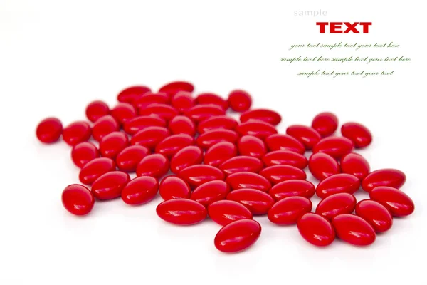 Červené léčivé prášky na bílém pozadí s prostorem pro text — Stock fotografie