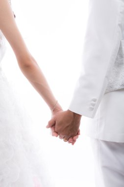 Gelin ve damat beyaz arkasında izole elele closeup