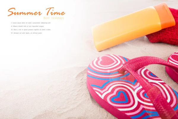 Flipflops ,sunscreen,towel on sand beach — Stock Photo, Image