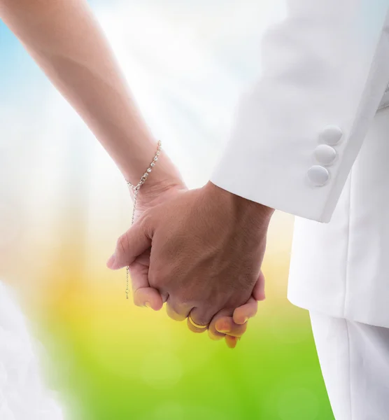 Close-up van bruid en bruidegom hand in hand geïsoleerd op witte achterzijde — Stockfoto