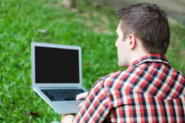 Ritratto di giovane uomo con laptop all'aperto — Foto Stock