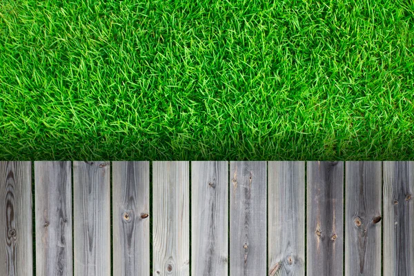 Fresca primavera erba verde con pavimento in legno — Foto Stock