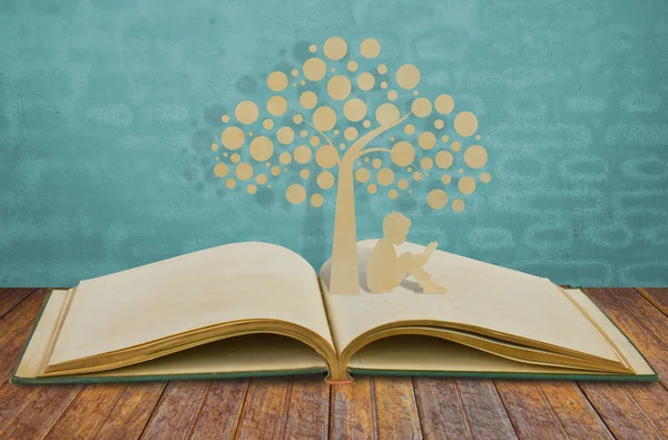 Il taglio di carta di bambini legge un libro sotto albero su libro vecchio — Foto Stock